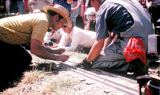 Ed Yungling hammering golden spike, with Milon Thorley holding the tie in place. 